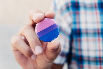 man with a bisexual pride flag badge.