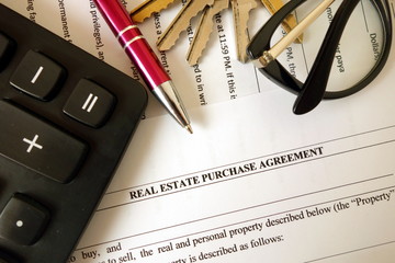 Real estate purchase agreement for filling with pen calculator keys and glasses