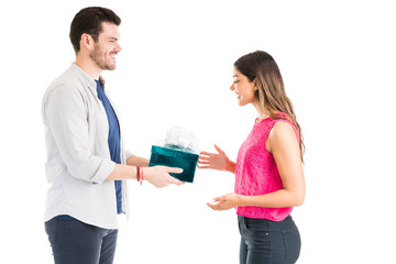 Happy Woman Receiving Gift From Man Against Plain Background