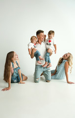 Naklejka premium Young family spending time together and smiling. Parents with young girl and little sons playing and laughting. Family lifestyle. Mother's, father's day, togetherness, parenthood, kid's rights concept