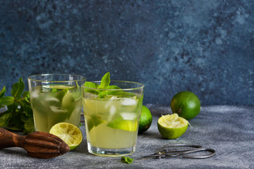 Summer cold drink - mahito with lime and mint on a concrete dark background.