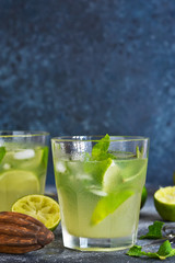 Summer cold drink - mahito with lime and mint on a concrete dark background.