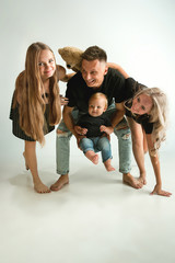 Happy father holding adorable little son and smiling at camera. Young parents playing with son and daughter. Family lifestyle. Father's, mother's day, togetherness, parenthood and kid's rights concept