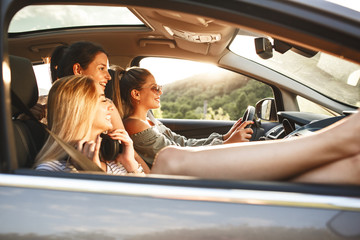 Three best female friends travel together.They drives a car and making fun.Summer vacation.