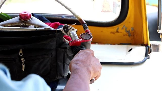 Close-up of the handlebar of tuk tuk while driving. Riding a traditional three-wheeled motorcycle on the street of Bangkok.