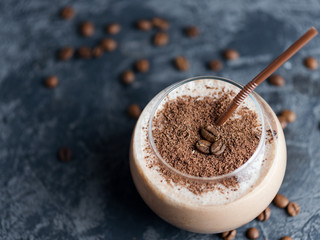 Chocolate coffee smoothie in a glass on a concrete table with copyspace