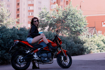 Fototapeta na wymiar young woman on a red motorcycle