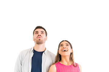Hispanic Couple Looking Up Against Plain Background