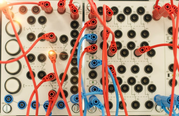 Selective focus. Blurred and de-focus on red and blue jumper cables connect into training set relay...