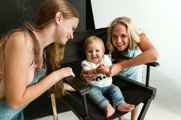 Young family spending time together and smiling. Mom with young daughter and little son playing and laughting. Family lifestyle. Mother's, father's day, togetherness, parenthood, kid's rights concept.