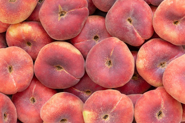 Fresh saturn peaches or donut peaches piled up