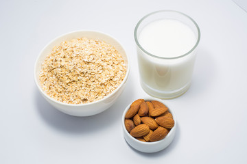 Healthy breakfast ingredients glass of milk, Almond nut and oats