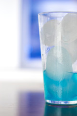 Generic blue berry syrup cocktail image. Close-up view water drops details. Cold drink for hot summer vacation holidays. Alcoholic drinks Blue Lagoon, Frostbite, Margarita, Hawaiian, Sapphire, Curacao