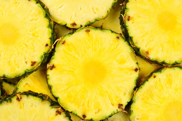 Pineapple juicy yellow slices background. Top view.
