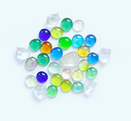 Multicolored glass round crystals on a light background.