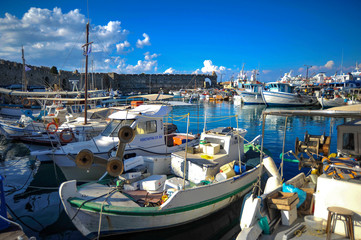 Obraz premium Under the shadow of the fortress walls of the Rhodes Knights today yachts, pleasure boats, fishing boats and cruise ships moor.