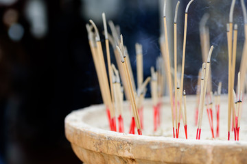 Incense sticks burning in old pot in the temple