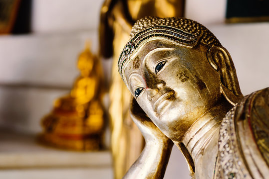 Close up face of golden buddha statue reclining