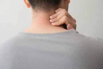 Photograph of a man from the back with pain and neck injury