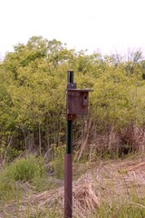 A close view of the old wood birdhouse in the grass prairie.
