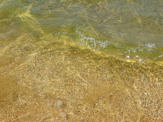  A fragment of a sandy beach with a wave running over it.              