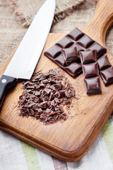 Chopped dark chocolate on wooden cutting board