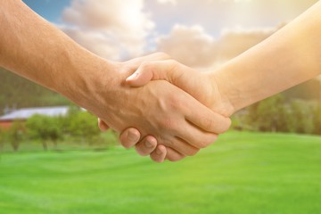 Business handshake and business buildings on light background