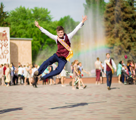 Happy young graduate with hands up is happy to finish school year. Education success concept