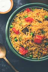 Tomato Rice also known as Tamatar Pilaf/pulav made using basmati rice, served in a bowl. selective focus