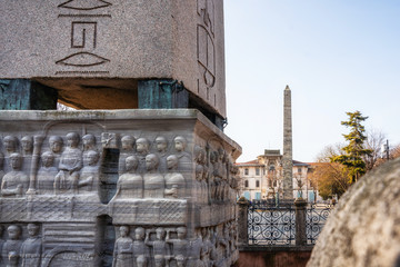 Details of the bas relief of the pedestal of Theodosius Obelisk and Walled Obelisk on background on Hippodrome of Constantinople in Istanbul, Turkey