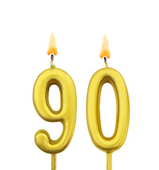 Burning golden birthday candle isolated on white background, number 90