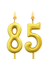 Burning golden birthday candles on white background, number 85
