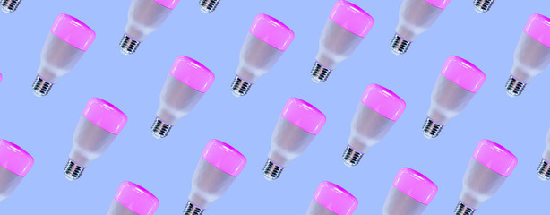 Pattern made of smart Home RGB pink and purple bulb lamp in trendy lavender pastel backlight. LED Bulb, multicolor backdrop inspired by neon trend. Top view, copy space for your design