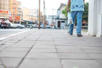 Obraz premium Men are walking on the footpath with carrying bird food bags.