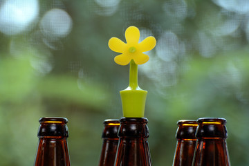 neck dark bottles and a rubber stopper in the form of a flower on a blurred green background. The...
