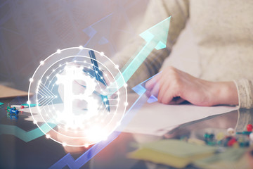 Cryptocurrency hologram over woman's hands writing background. Concept of blockchain. Multi exposure