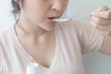 Women taking liquid medicine, health care concepts, people and medicine