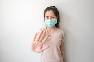 Stop the infection! Healthy woman showing gesture "stop". Asian women wear hygiene masks to prevent germs and dust and do not stop or stop. Thoughts about health care.