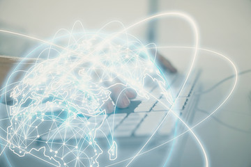 Double exposure of businessman working on laptop on background. International business hologram in front. Concept of success.