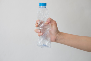 Hand holding a recyclable plastic bottles on white background.