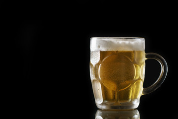 Light beer on black background. Beer glass