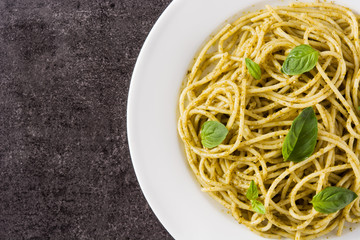Spaghetti pasta with pesto sauce on black background. Top view