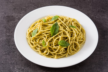Spaghetti pasta with pesto sauce on black background. 