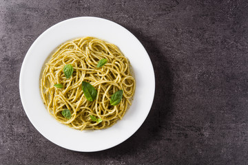 Spaghetti pasta with pesto sauce on black background. Top view. Copyspace