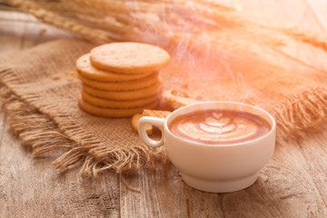 Fototapeta na wymiar Hot coffee with late art and biscuits