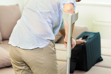 Woman With Crutches taking bag on the couch