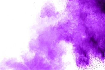 Purple color powder explosion cloud  on white background.Closeup of purple dust particles splash on...