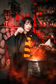 Beautiful girl with long hair conjures. Young witch with a magic wand