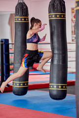 Muay thai girl practicing with heavy bag