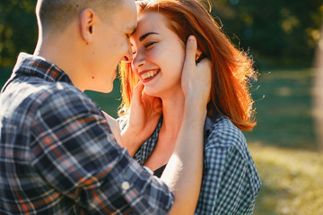 Cute couple in a park. Lady with red hair.